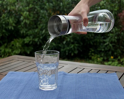 Symbol Wasser wird in Glas geschüttet